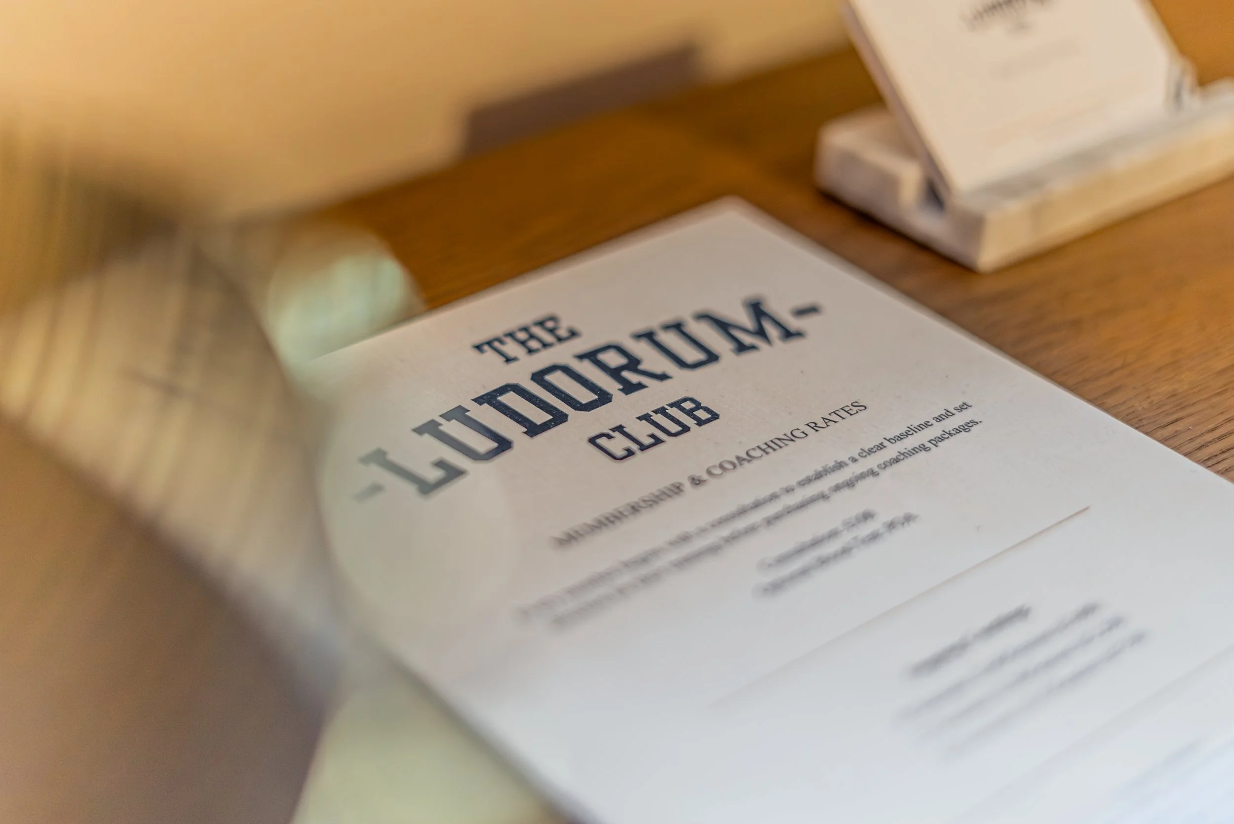 The printed Ludorum Club membership and coaching rates card on the consultation desk